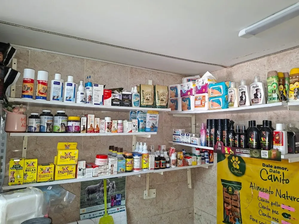 Estantería de cosméticos y farmacia veterinaria en Patitas Pet Shop con shampoos, perfumes, cepillos Furminator y productos de cuidado para mascotas